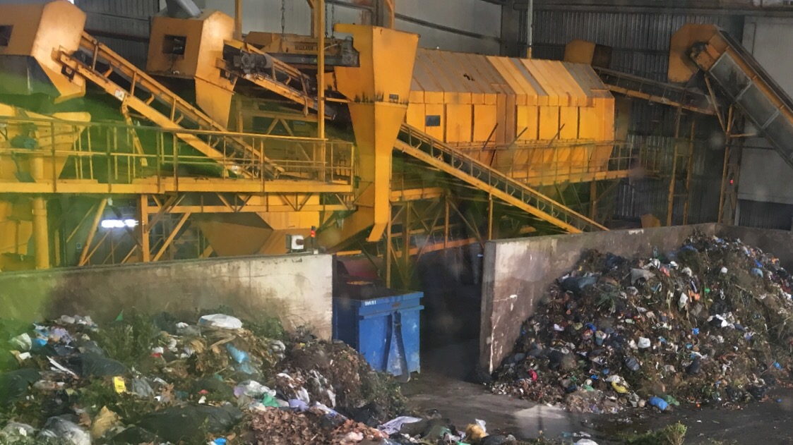A trommel separating municipal waste by size. Everything after this point works on a narrower size band.