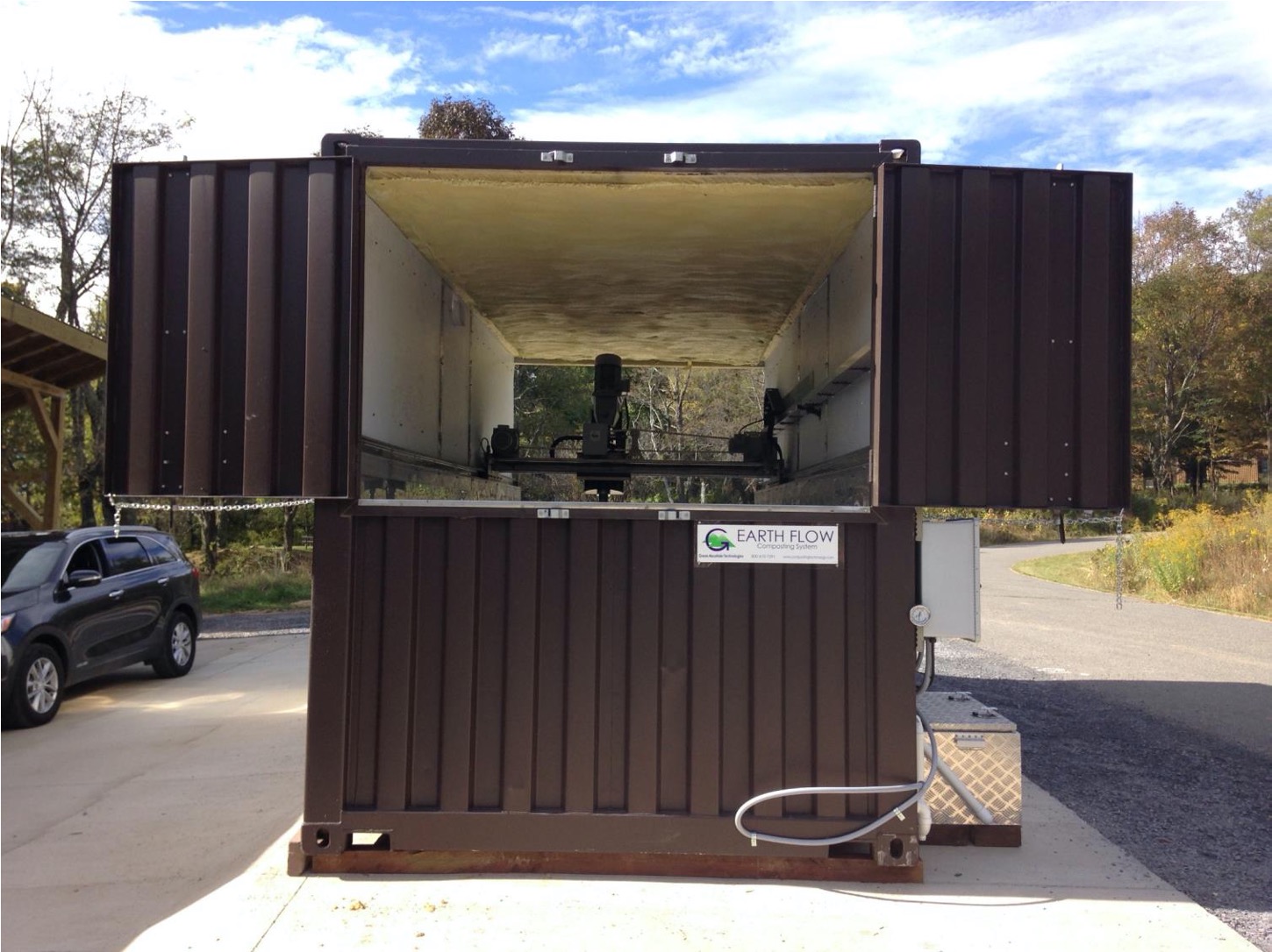 An in-vessel composter: the enclosure exists so that temperature, moisture and airflow are variables an operator sets rather than weather the pile endures.