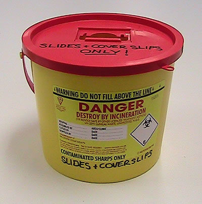 A sharps container. The colour coding is the whole point: this is a compliance object before it is a material.