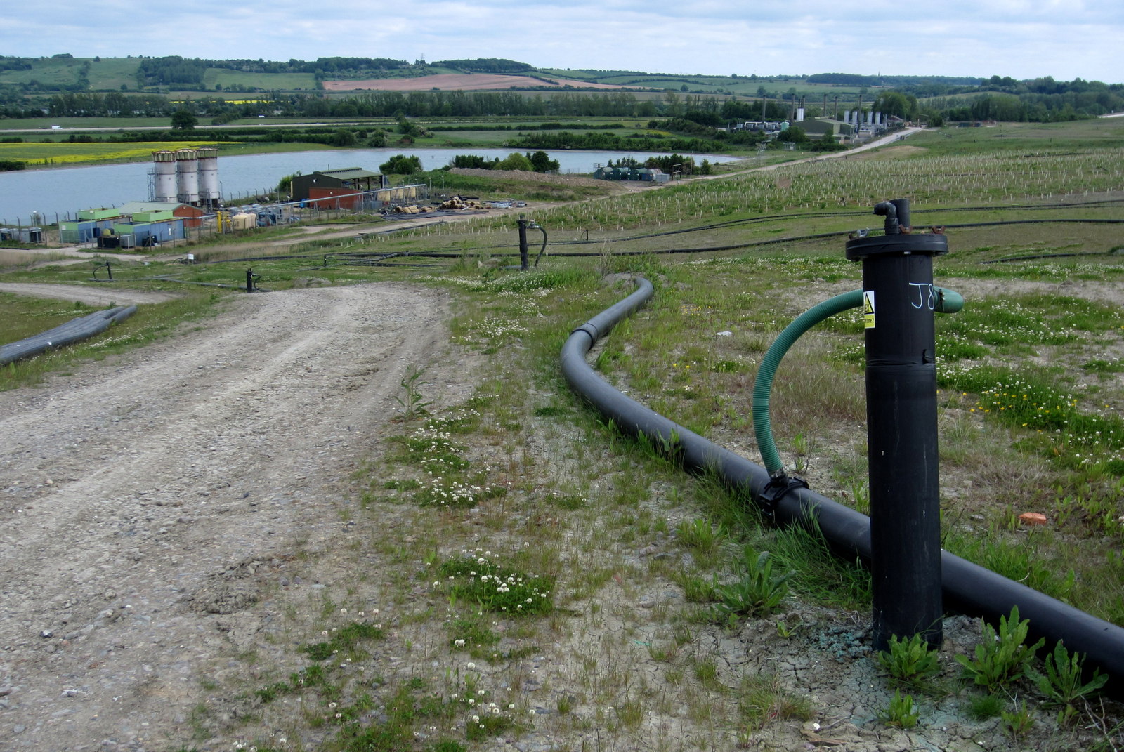 Collection headers on a landfill surface. Each branch ends at a wellhead with its own vacuum setting.