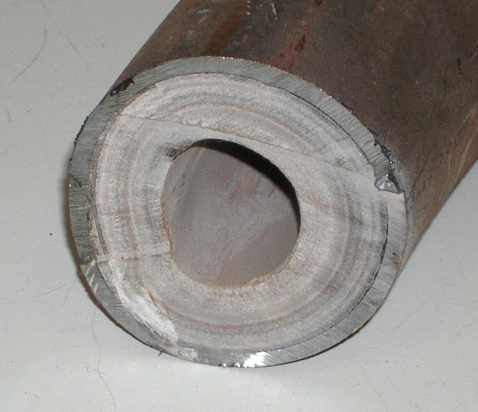 A pipe cross-section closed down by mineral scale. Struvite does this to digester and centrate lines.